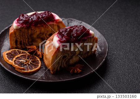 Cinnamon roll, a sweet bun with citrus, cherries, and chocolate, a Danish dessert with cream Cinnamon roll, a sweet bun with citrus, cherries, and chocolate, a Danish dessert with cream 133503160