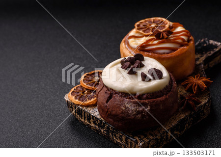 Cinnamon roll, a sweet bun with citrus, cherries, and chocolate, a Danish dessert with cream Cinnamon roll, a sweet bun with citrus, cherries, and chocolate, a Danish dessert with cream 133503171