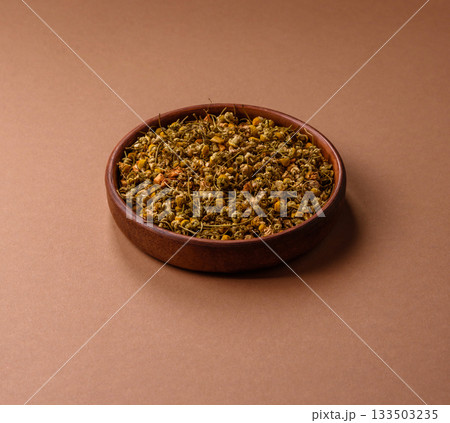 Dried chamomile flowers, herbal tea in a bowl for a hot morning drink. Dried chamomile 133503235