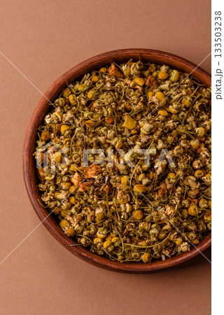 Dried chamomile flowers, herbal tea in a bowl for a hot morning drink. Dried chamomile Dried chamomile flowers, herbal tea in a bowl for a hot morning drink. Dried chamomile 133503238