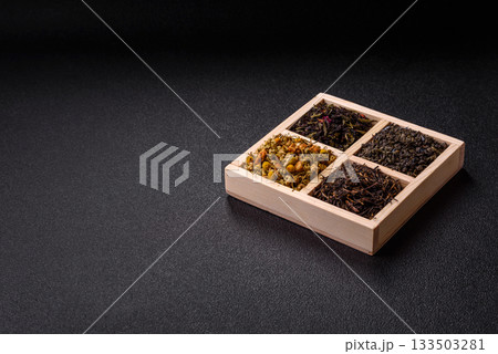 A wooden box with several types of dried tea, green, black, fruit, and chamomile. Dry tea in the box A wooden box with several types of dried tea, green, black, fruit, and chamomile. Dry tea in the box 133503281