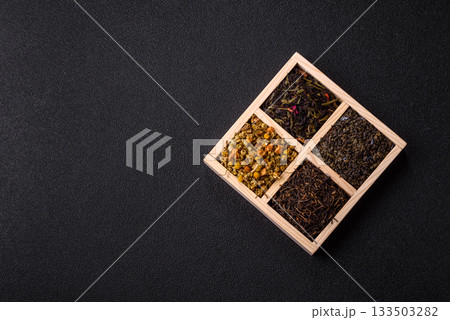 A wooden box with several types of dried tea, green, black, fruit, and chamomile. Dry tea in the box A wooden box with several types of dried tea, green, black, fruit, and chamomile. Dry tea in the box 133503282