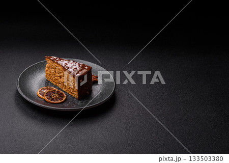 A slice of sweet layered cake covered in chocolate with nuts and caramel. A slice of chocolate cake A slice of sweet layered cake covered in chocolate with nuts and caramel. A slice of chocolate cake 133503380