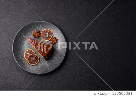 A slice of sweet layered cake covered in chocolate with nuts and caramel. A slice of chocolate cake 133503381