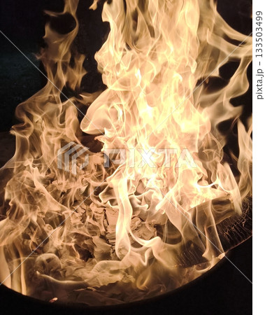 Close-up of bright, dancing flames in an outdoor fire pit Close-up of bright, dancing flames in an outdoor fire pit 133503499