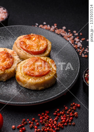 Round fish or chicken cutlets baked with tomato and cheese. Fish cutlets 133503514