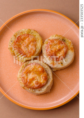 Round fish or chicken cutlets baked with tomato and cheese. Fish cutlets 133503525