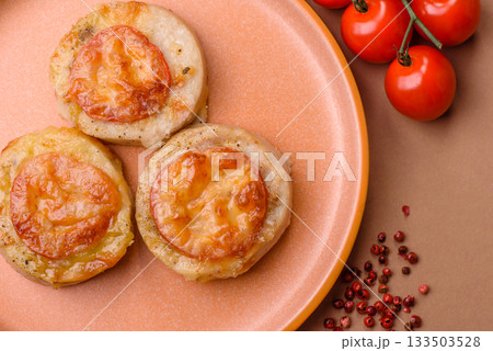 Round fish or chicken cutlets baked with tomato and cheese. Fish cutlets 133503528