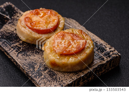 Round fish or chicken cutlets baked with tomato and cheese. Fish cutlets Round fish or chicken cutlets baked with tomato and cheese. Fish cutlets 133503543