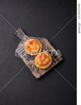 Round fish or chicken cutlets baked with tomato and cheese. Fish cutlets Round fish or chicken cutlets baked with tomato and cheese. Fish cutlets 133503549