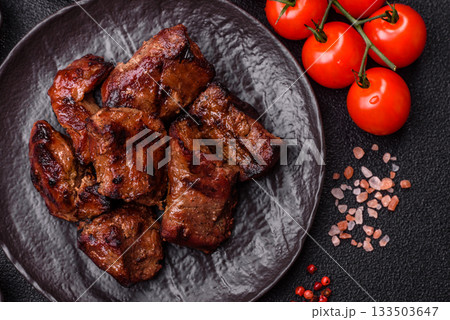 Beef, grilled meat in pieces, or kebab with sauce and vegetables. Beef in pieces 133503647
