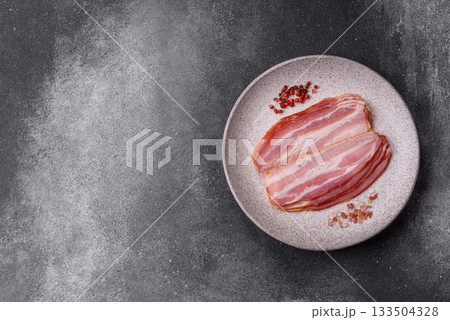 Meat, raw pork bacon sliced, organic food, protein for snacks. Raw bacon as a background Meat, raw pork bacon sliced, organic food, protein for snacks. Raw bacon as a background 133504328