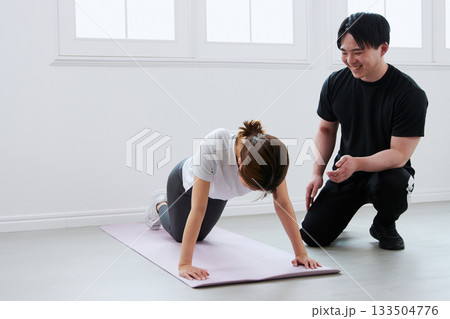 パーソナルトレーナーにトレーニングを受ける若い女性 パーソナルトレーナーにトレーニングを受ける若い女性 133504776