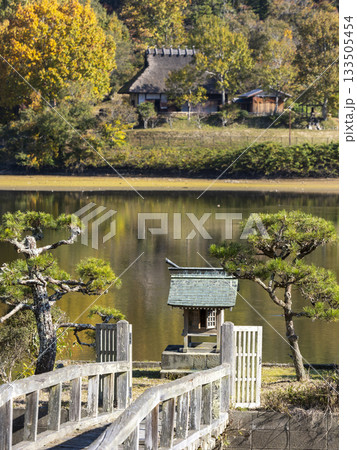 池に祀られた神社と茅葺きの古民家 133505454
