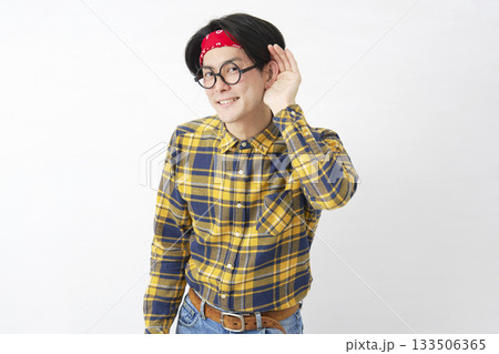 アキバ系の男性 耳に手を当てて聴く 白背景 アキバ系の男性 耳に手を当てて聴く 白背景 133506365