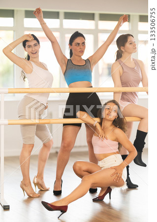 Expressive young women in heels posing at ballet barre for dance class 133506755