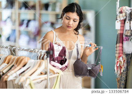 Young Latina chooses bras and underwear in the store 133506784