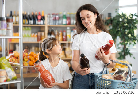 Child girl with mother choose consider juice 133506816