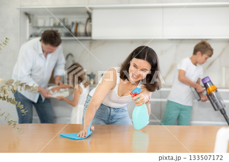 Happy family with two children doing cleaning in kitchen 133507172