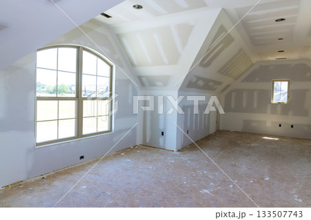 Bright room in modern home features large windows bare drywall, awaiting finishing touches decor. 133507743