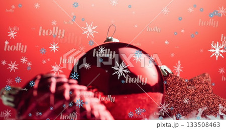 Displaying Christmas bauble on tabletop, glittery star, coiled ribbon, snowflake and holly text 133508463