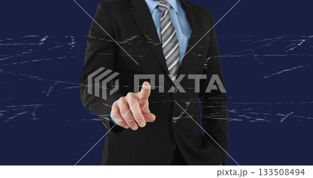 Pointing businessman wearing black suit, light blue shirt, striped tie at studio with glitch lines 133508494
