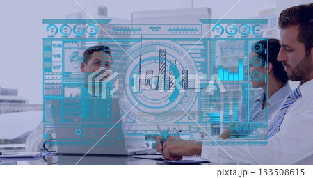Floating holographic dashboard in office with suited coworkers, laptop, notebook and documents 133508615