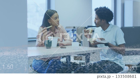 Chatting coworkers eating lunch in office break room, with takeout box, chopsticks and fork 133508681