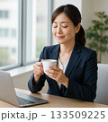 コーヒーを飲んでリラックスする女性ビジネスパーソン（Businesswoman Relaxing w 133509225