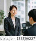 同僚に挨拶する女性ビジネスパーソン（Businesswoman Greeting a Colleag 133509227