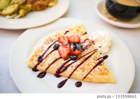 Sweet Dessert Crepe with Berries, Syrup, and Whipped Cream Sweet Dessert Crepe with Berries, Syrup, and Whipped Cream 133509663