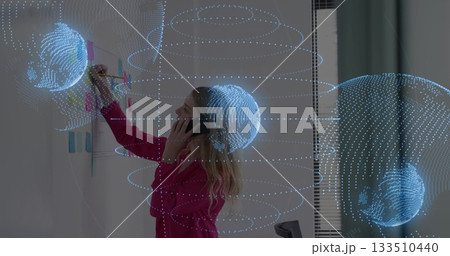 Woman wearing pink blazer writing on whiteboard and holding phone in office, with holographic rings Woman wearing pink blazer writing on whiteboard and holding phone in office, with holographic rings 133510440