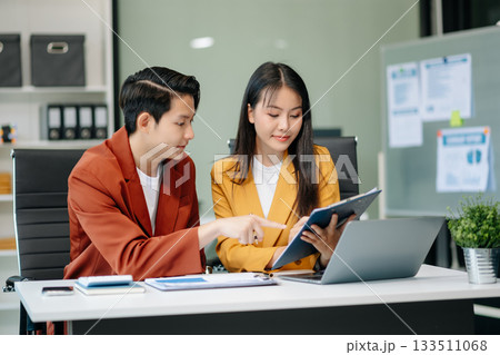 Businesswomen work and discuss their business plans. A Human employee explains and shows her colleague the results paper Businesswomen work and discuss their business plans. A Human employee explains and shows her colleague the results paper 133511068