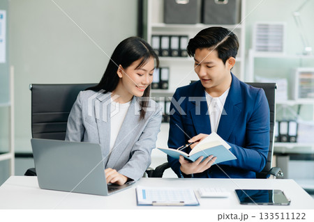 Businesswomen work and discuss their business plans. A Human employee explains and shows her colleague the results paper Businesswomen work and discuss their business plans. A Human employee explains and shows her colleague the results paper 133511122