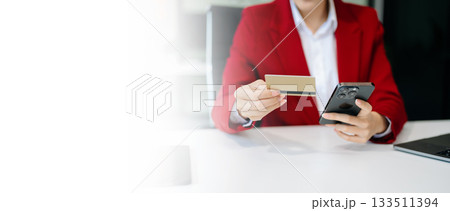 Woman hand using a laptop, smartphone and tablet and writing notebook at the office of her business online shopping Woman hand using a laptop, smartphone and tablet and writing notebook at the office of her business online shopping 133511394