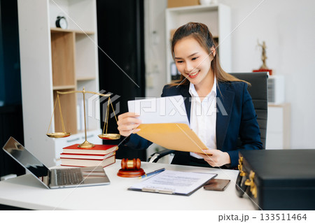 Asian lawyer woman working with a laptop and tablet in a law office. Legal and legal service concept. Asian lawyer woman working with a laptop and tablet in a law office. Legal and legal service concept. 133511464