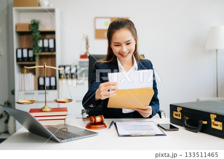 Asian lawyer woman working with a laptop and tablet in a law office. Legal and legal service concept. Asian lawyer woman working with a laptop and tablet in a law office. Legal and legal service concept. 133511465