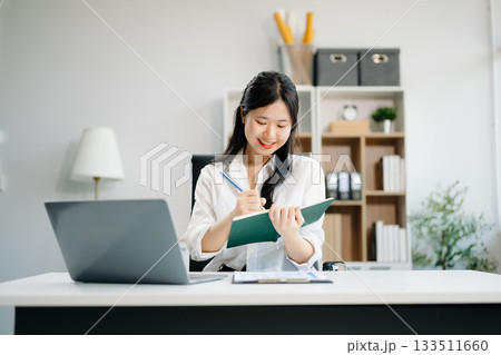 businesswoman working at office with laptop, tablet and taking notes on the paper. 133511660