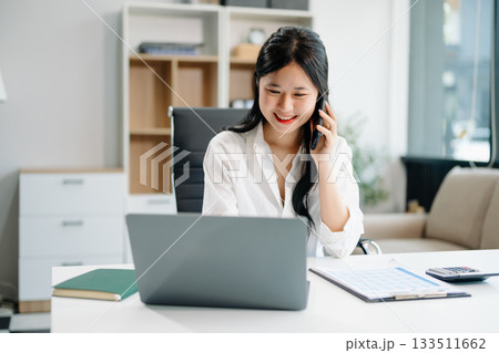 businesswoman working at office with laptop, tablet and taking notes on the paper. businesswoman working at office with laptop, tablet and taking notes on the paper. 133511662