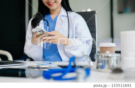 Asian Doctor working with mobile phone and stethoscope. Medical technology concept. Asian Doctor working with mobile phone and stethoscope. Medical technology concept. 133511691