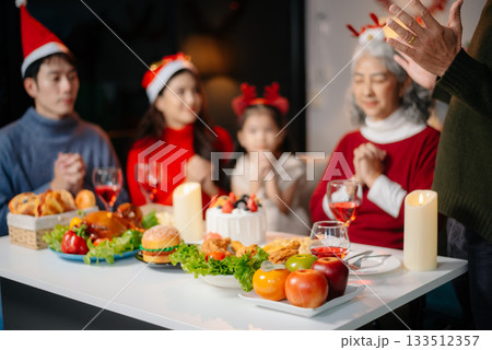 Joyful Asian family celebrating Christmas together with gifts, festive food, and decorations, capturing love, 133512357