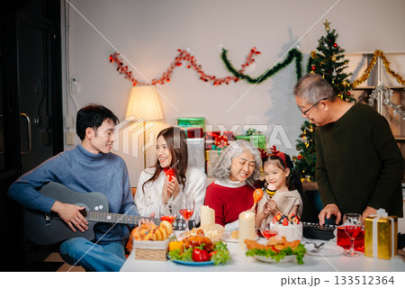 Celebrate Christmas with family in a cozy, festive setting filled with gifts, love, and joy. 133512364