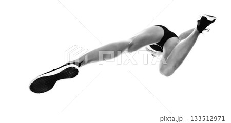 Low angle view of sportswoman long jumping 133512971