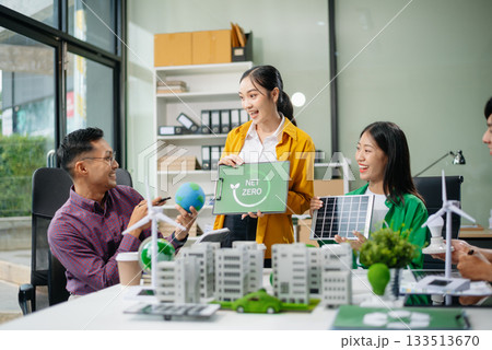 Asian professionals collaborate on sustainable energy solutions with wind turbines, solar panels, and eco friendly models 133513670