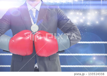 Midsection of businessman wearing boxing gloves in ring 133514338