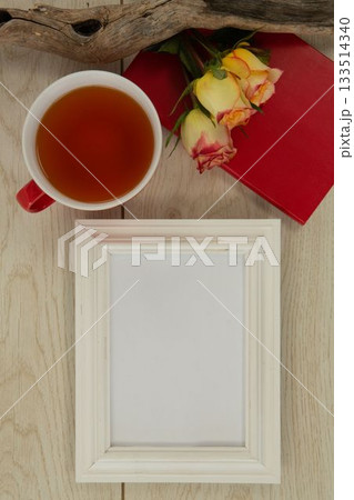 Photo frame, lemon tea, diary and flowers on wooden table Photo frame, lemon tea, diary and flowers on wooden table 133514340
