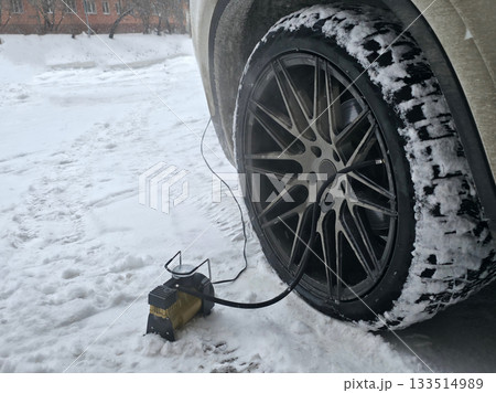 Car Tire Inflation in Snowy Winter Conditions 133514989