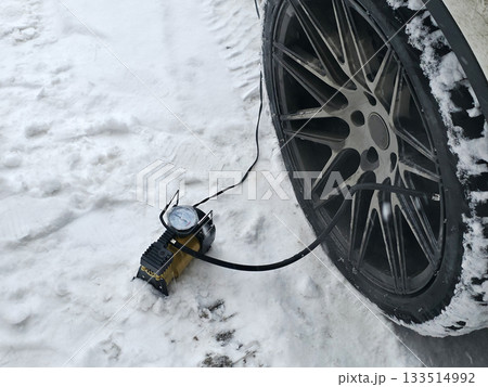 Car Tire Inflation in Snowy Winter Conditions 133514992