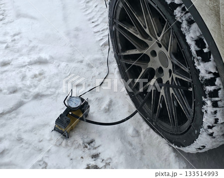 Car Tire Inflation in Snowy Winter Conditions 133514993