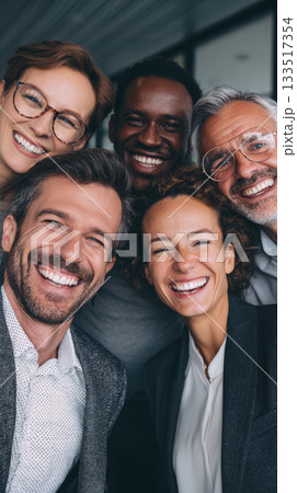 Happy multicultural business team smiling closely for camera in modern office, joyful coworkers sharing candid moment 133517354